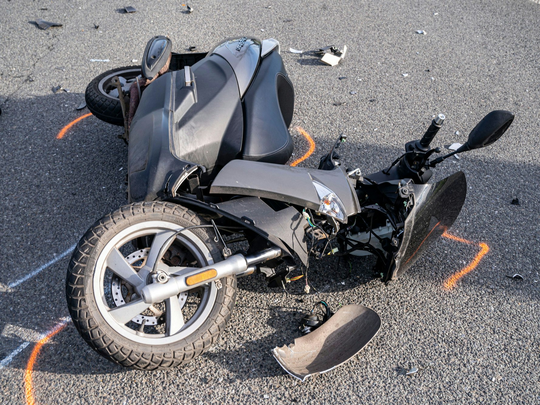 Ein Motorroller liegt nach einem Unfall auf der Straße.
