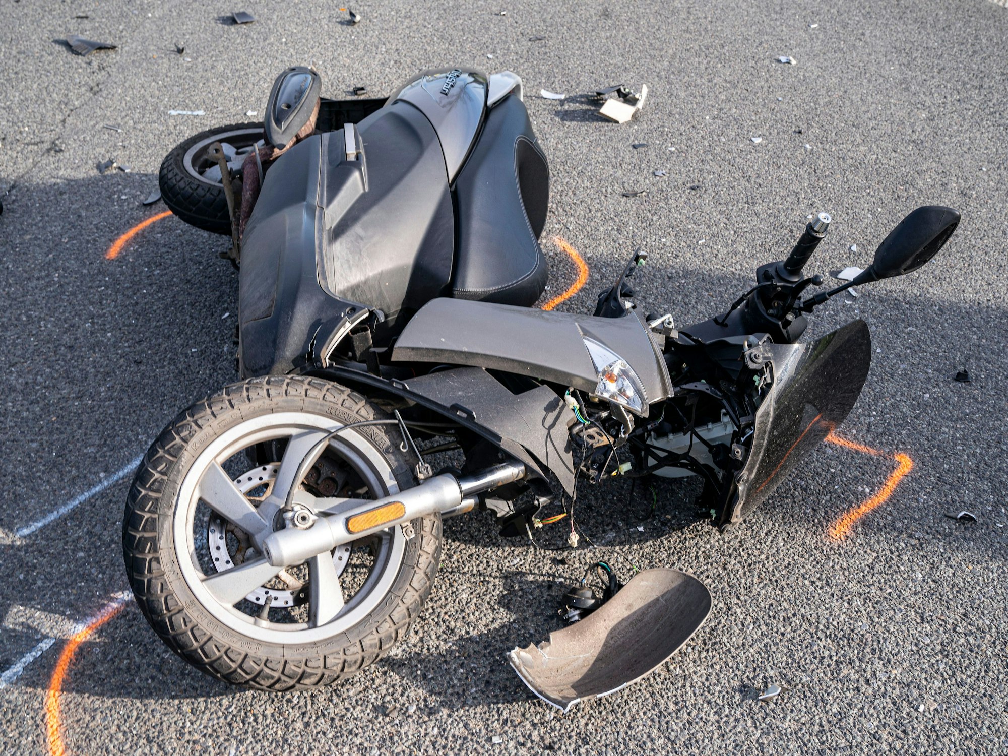 Ein Motorroller liegt nach einem Unfall auf der Straße.