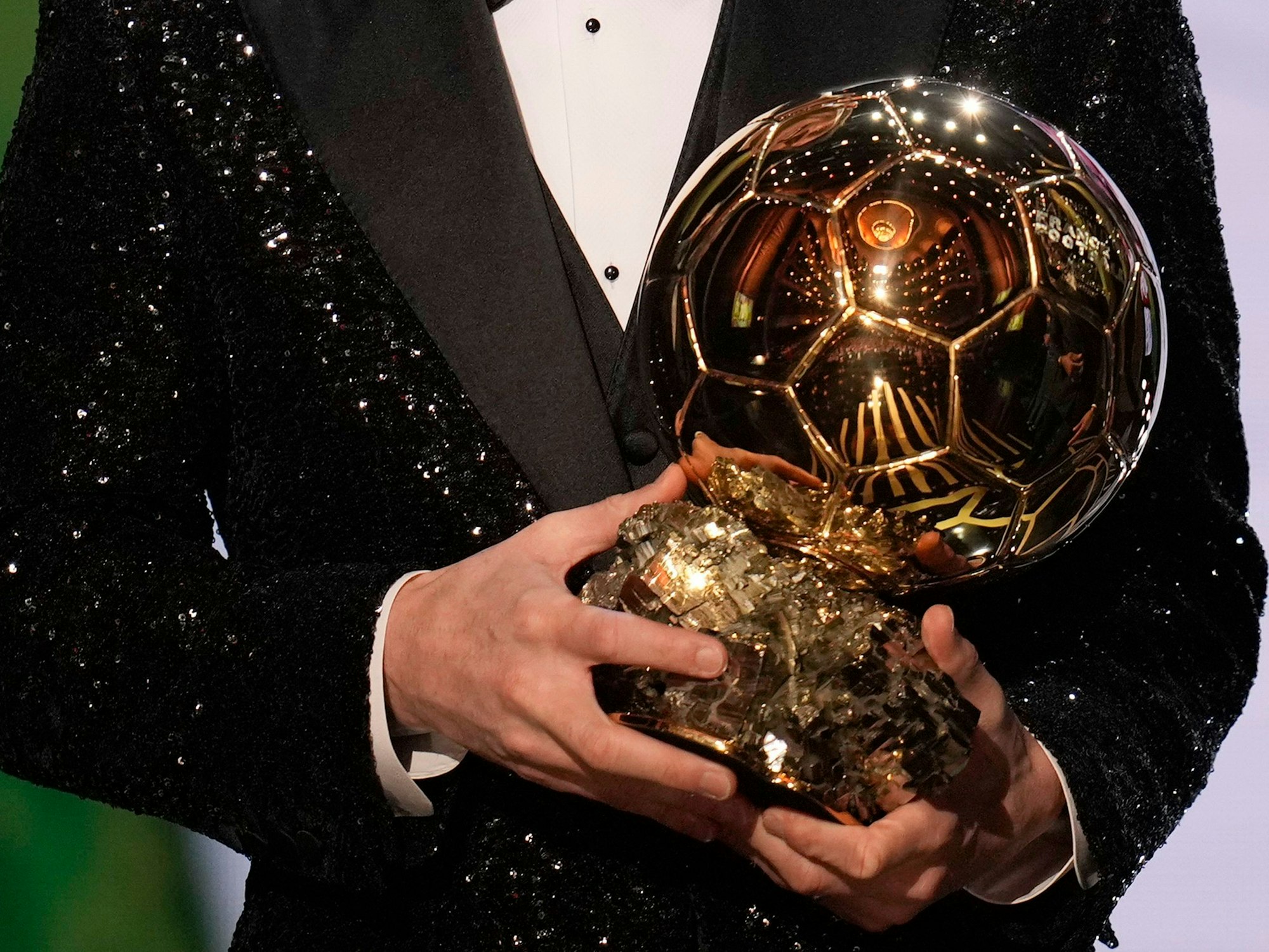 Lionel Messi hält die Ballon d'Or-Trophäe 2021 in den Händen.