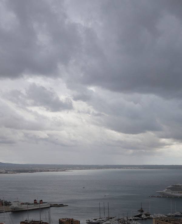 Dunkle Regenwolken hängen über der Bucht und dem Hafen von Palma de Mallorca.