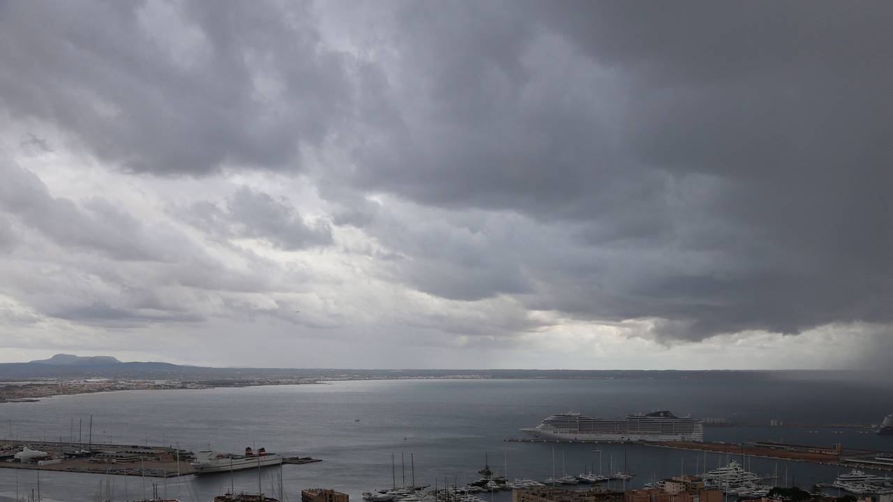 Dunkle Regenwolken hängen über der Bucht und dem Hafen von Palma de Mallorca.