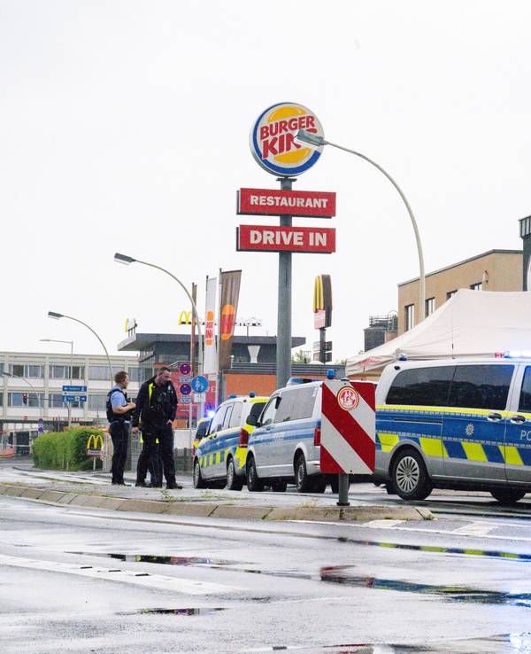 Der Bereich vor einer Burger-King-Filiale ist von der Polizei abgesperrt worden, davor stehen drei Polizeifahrzeuge soiwe mehrere Einsatzkräfte.