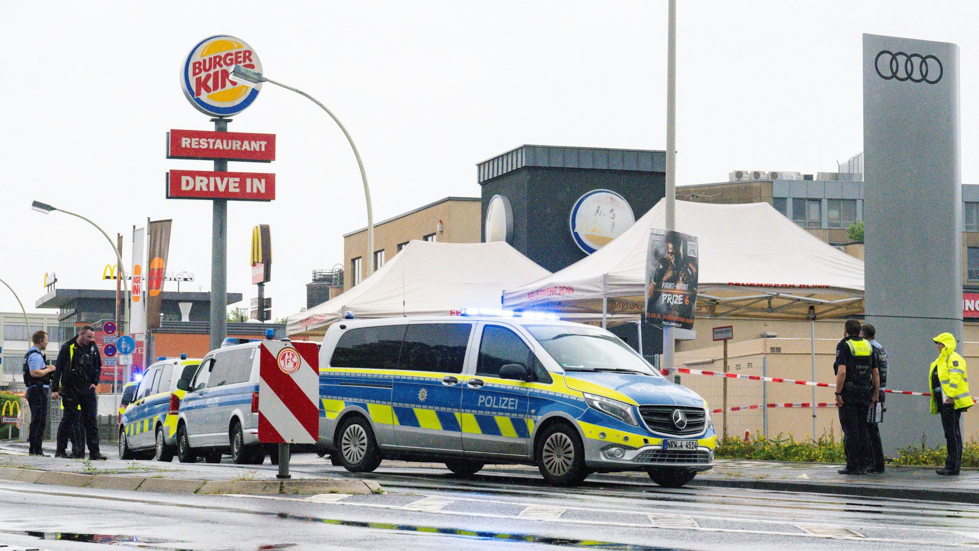 Der Bereich vor einer Burger-King-Filiale ist von der Polizei abgesperrt worden, davor stehen drei Polizeifahrzeuge soiwe mehrere Einsatzkräfte.