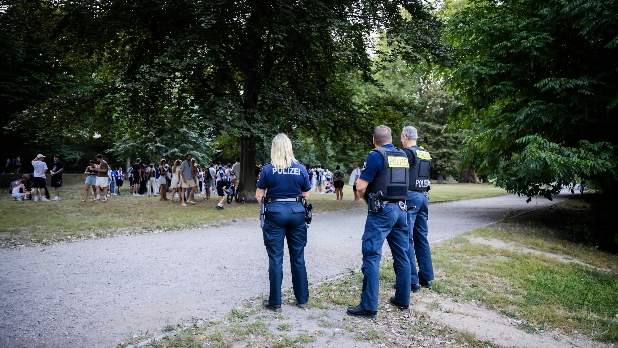 Polizisten beobachten ein Treffen von Herthas Reese mit Fans im Lietzenseepark.
