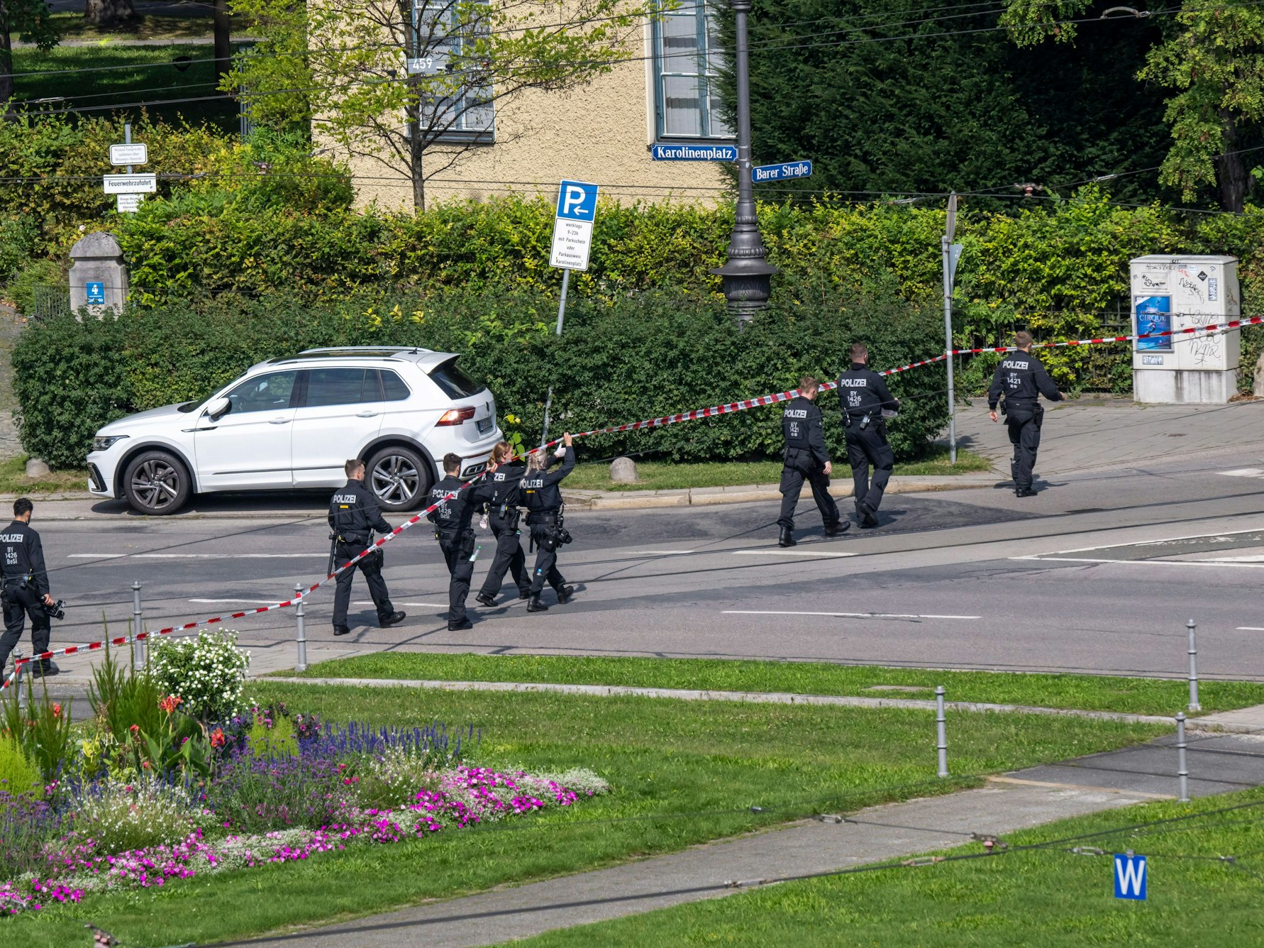 Polizisten gehen eine Straße am Karolinenplatz auf der Suche nach Spuren ab.