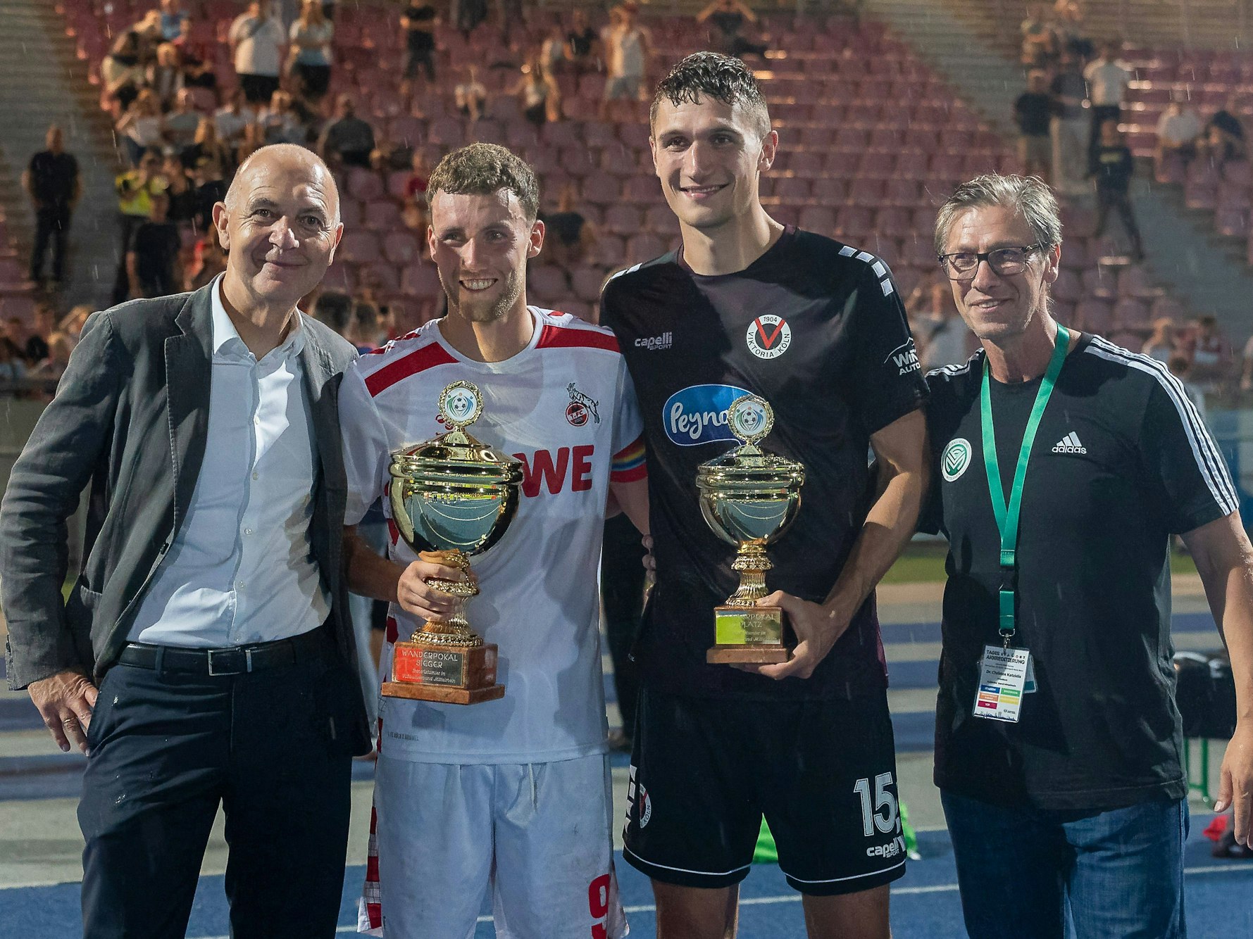 DFB-Präsident Bernd Neuendorf, FC-Profi Luca Waldschmidt, Viktoria-Profi Christoph Greger und FVM-Präsident Christos Katzidis posieren für ein Foto.