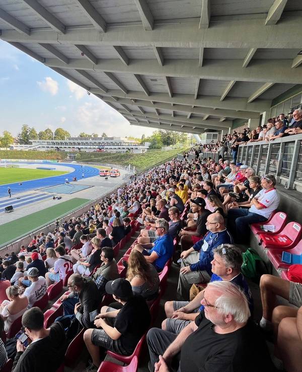 Fans sitzen auf der Tribüne im Sportpark Nord.