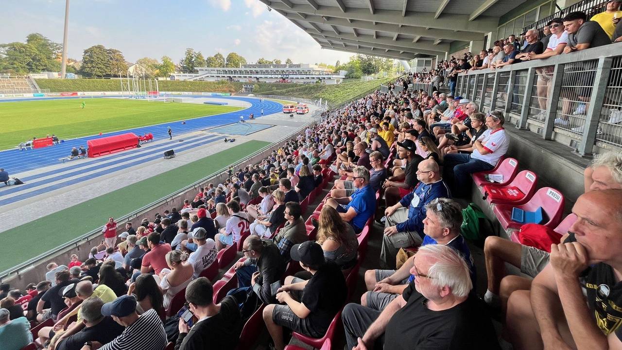 Fans sitzen auf der Tribüne im Sportpark Nord.