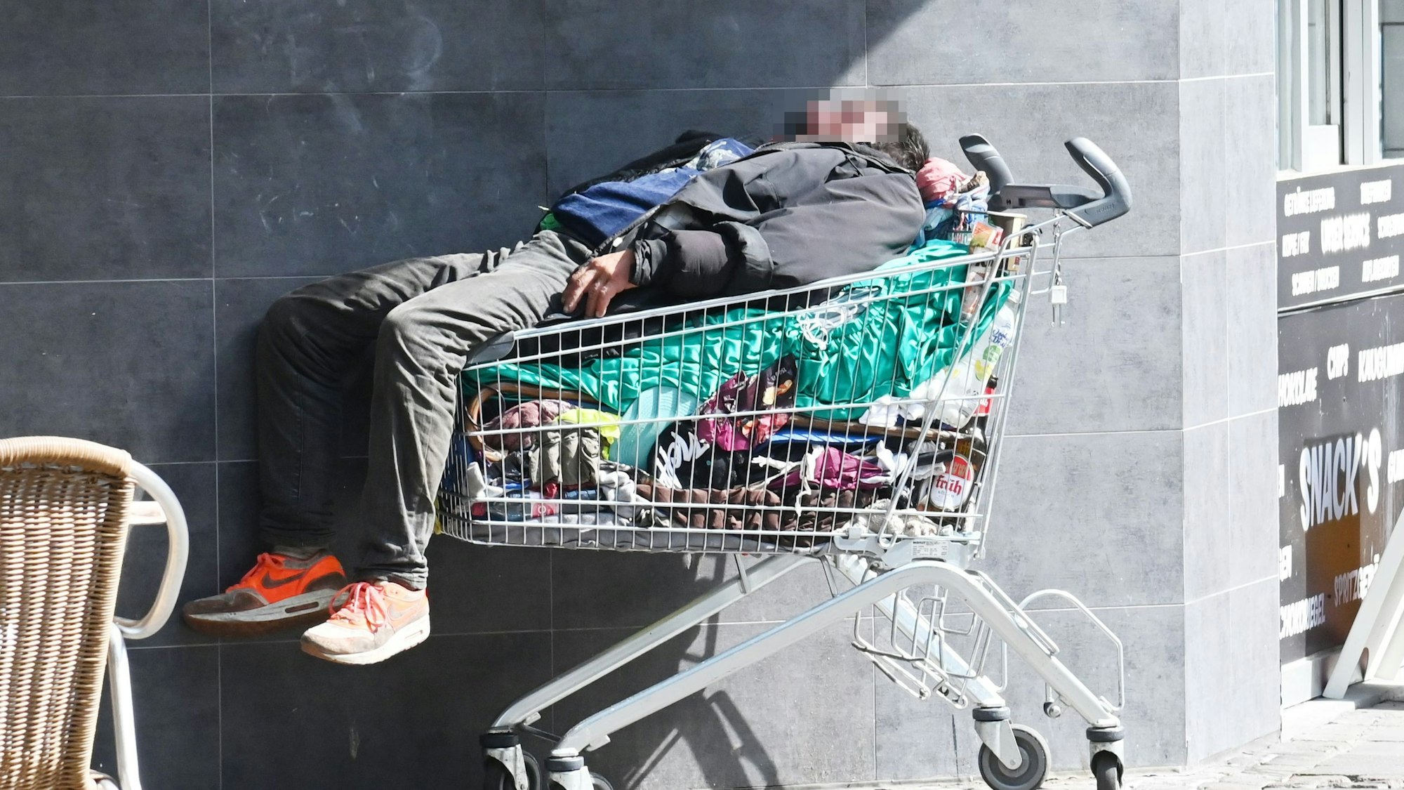 Ein Obdachloser schläft in einem Einkaufswagen. Das Symbolfoto wurde in Köln aufgenommen.
