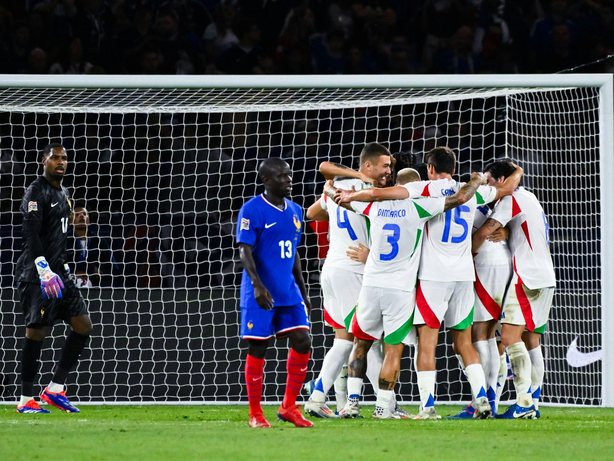 Die italienischen Spieler jubeln über ein Tor im Nations-League-Spiel gegen Frankreich am 6. September 2024. Links die beiden enttäuschten Franzosen Ngolo Kanté und Torwart Mike Maignan.