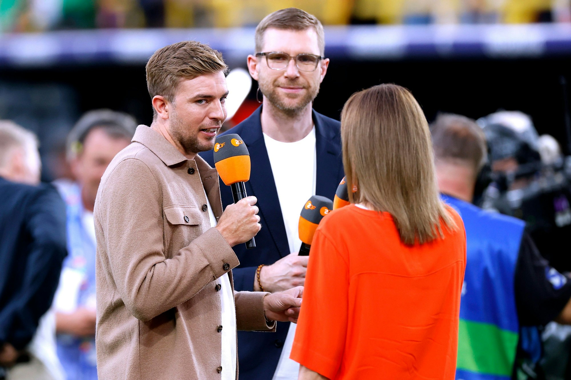 Die ZDF-Experten Christoph Kramer (l.) und Per Mertesacker gemeinsam mit Moderatorin Kathrin Müller-Hohenstein beim EM-Achtelfinale zwischen Deutschland und Dänemark am 29. Juli 2024.