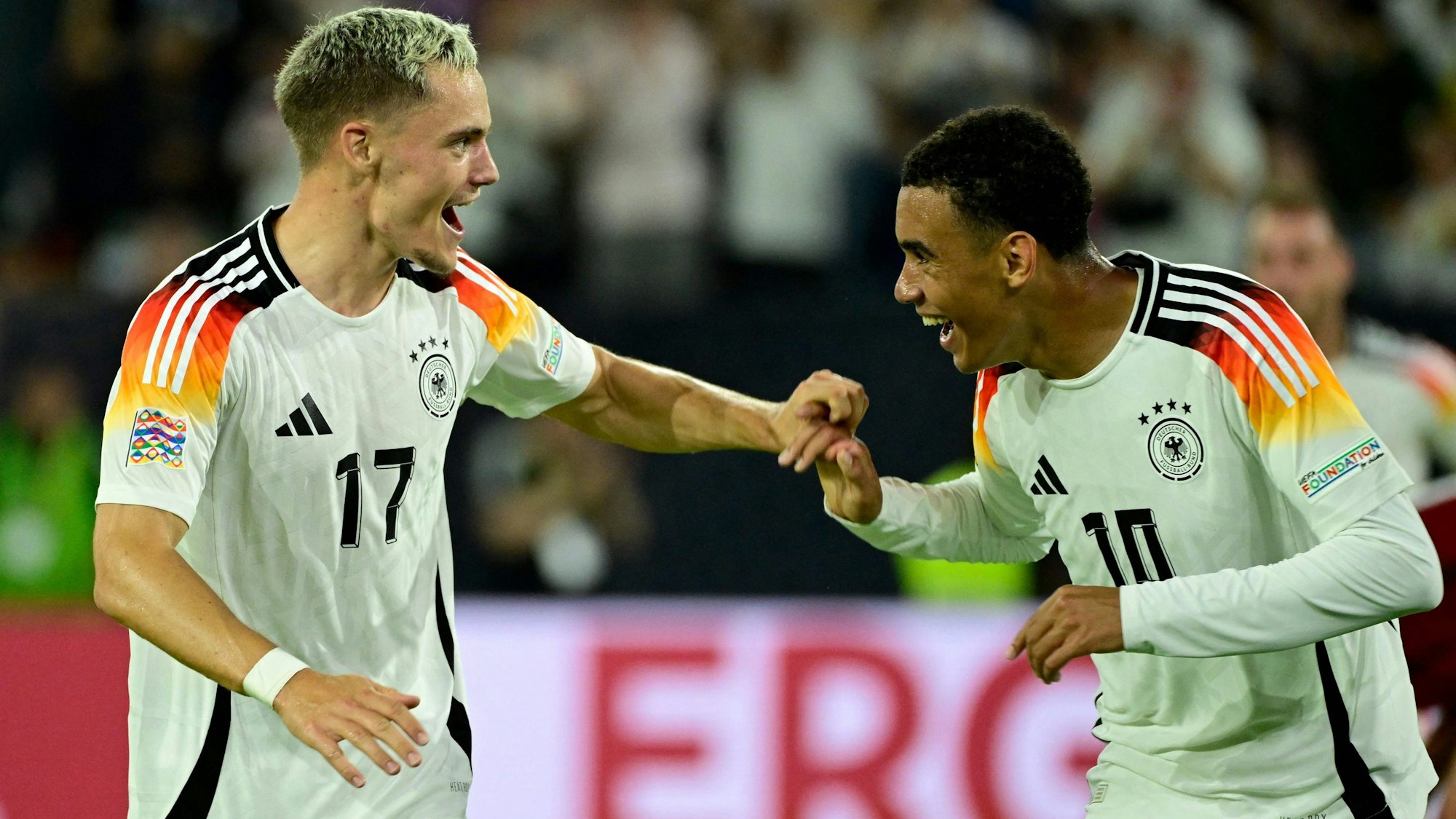 Florian Wirtz feiert mit Jamal Musiala nach einem Tor.