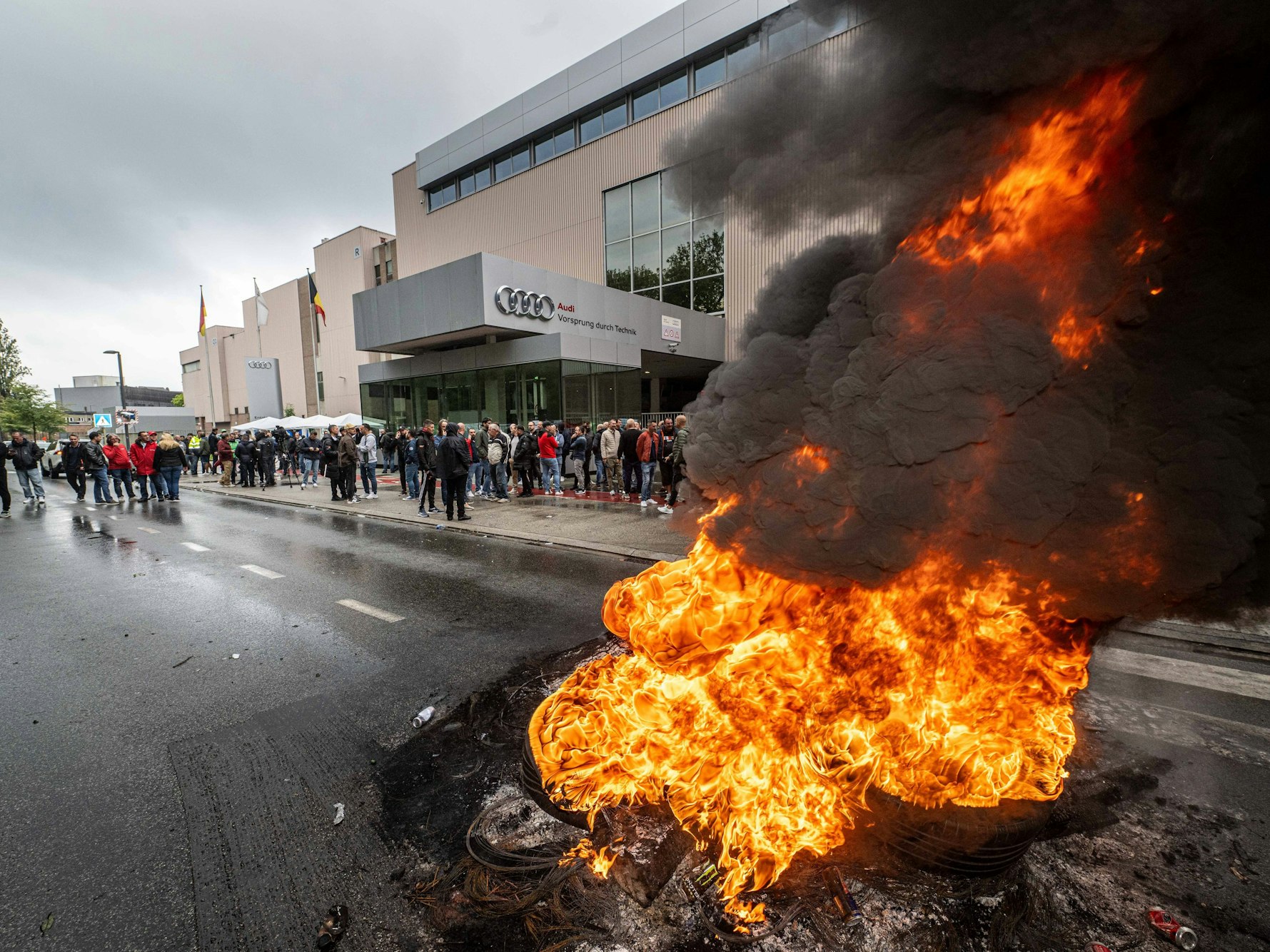 Arbeiter versammeln sich vor dem Audi-Werk Brüssel in Vorst-Forest neben brennenden Autoreifen. Die Unternehmensleitung kündigte an, dass das Werk geschlossen bleibt, bis die Arbeiter sich bereit erklären, die Produktion wieder aufzunehmen und Autos an die Händler zu liefern.
