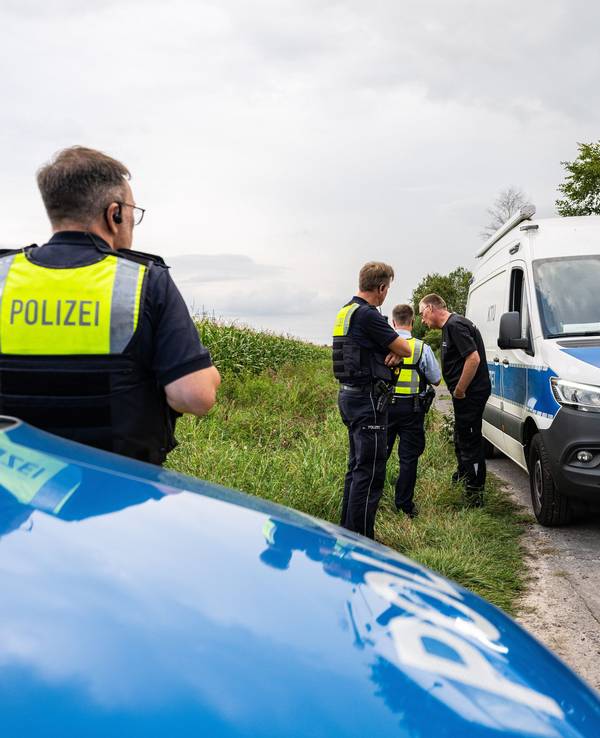 Gronau in NRW: Polizeibeamte der kriminaltechnischen Untersuchungsstelle (KTU) stehen am Montag (9. September 2024) am Rande eines Maisfeldes, wo am Sonntag zwei männliche Leichen gefunden wurden.
