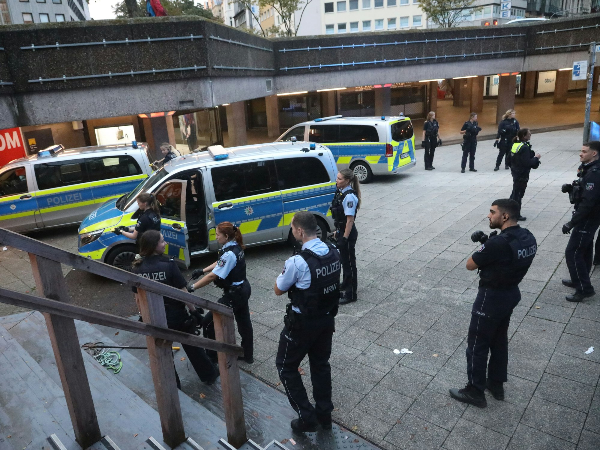 Drei Einsatzfahrzeuge der Polizei stehen am Ebertplatz, außerdem zahlreiche Polizistinnen und Polizisten.