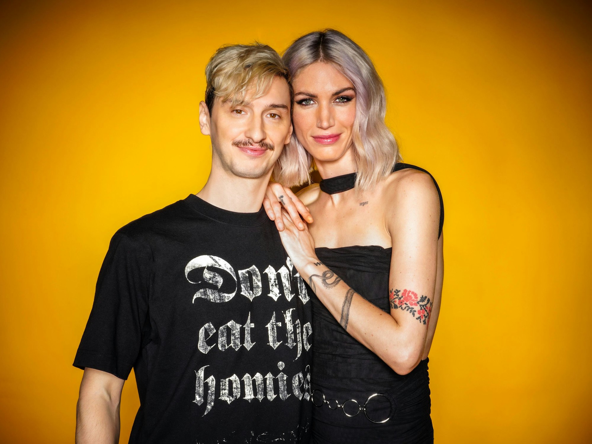 Das Foto zeigt das Sommerhaus-Paar Jakob Morgenstern und Tessa Bergmeier vor einer gelben Wand