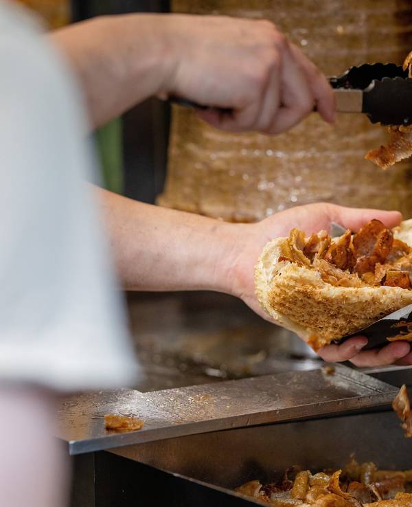 Ein Mitarbeiter einer Dönerbude legt Fleisch in einen Döner (Symbolbild): Das NRW-Ministerium nimmt den Döner ins Visier.