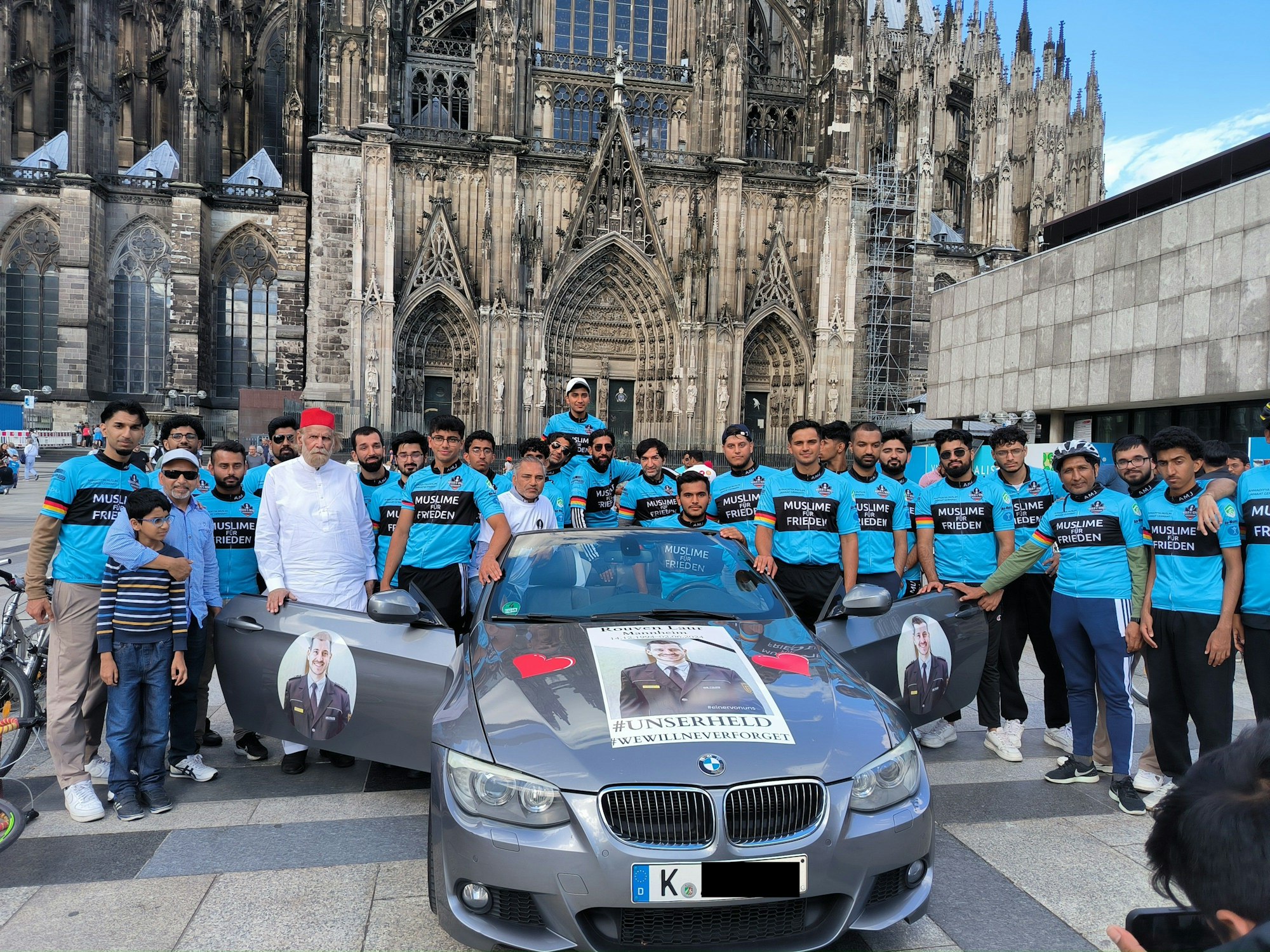 Eine Gruppe steht um ein Auto herum.
