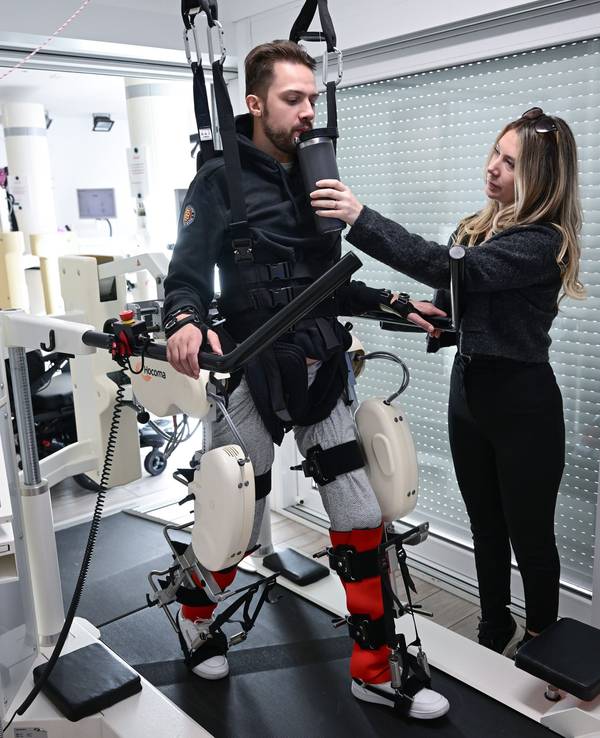 Der ehemalige Eishockeyspieler Mike Glemser () absolviert in einer Reha eine Übungseinheit bei einer Robotergestützten Gangtherapie. Rechts seine Freundin und Stütze Lara Lindmayer.