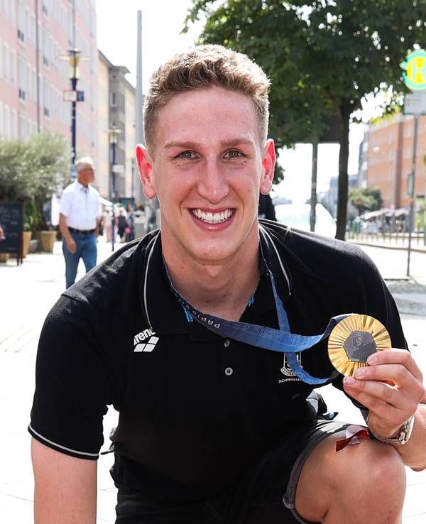 Lukas Märtens präsentiert seine Goldmedaille auf dem Sports Walk of Fame in Magdeburg.