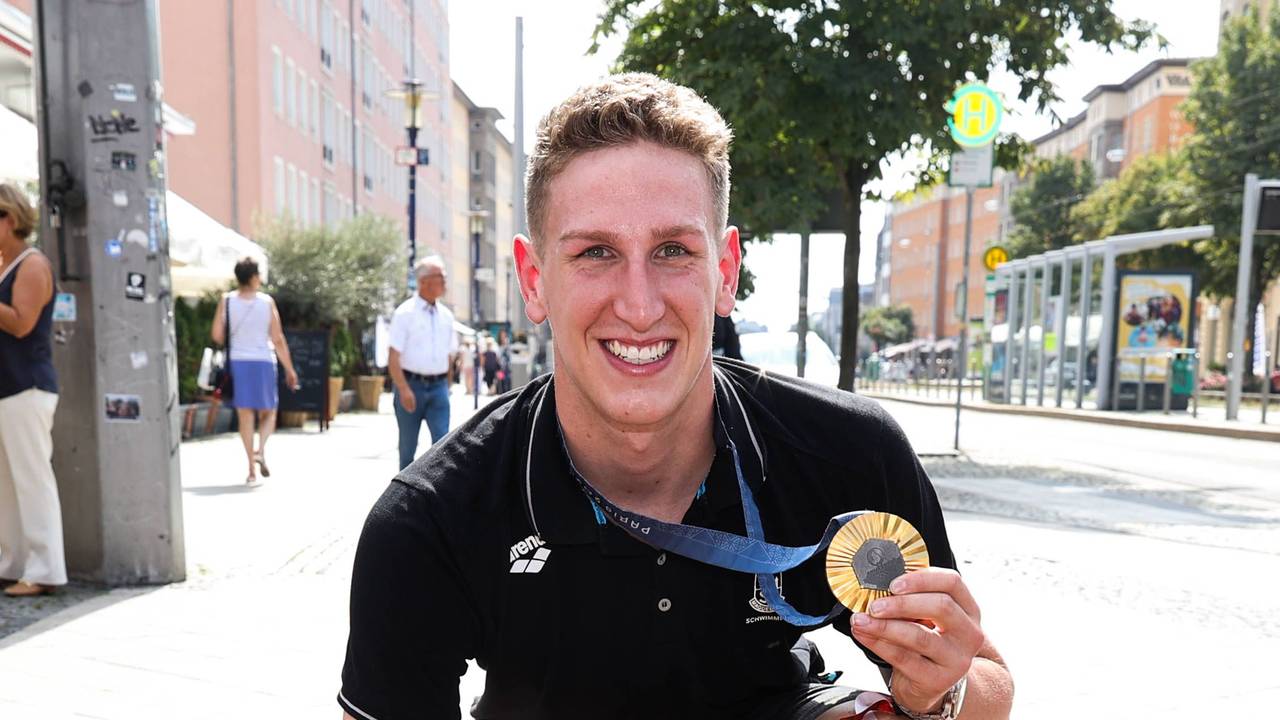 Lukas Märtens präsentiert seine Goldmedaille auf dem Sports Walk of Fame in Magdeburg.