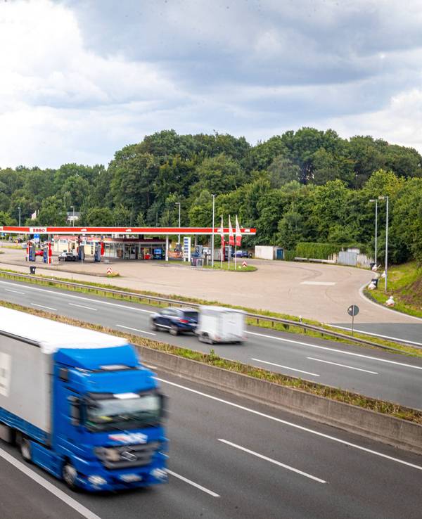 Blick auf die A1 und die Raststätte Münsterland West, es sind viele Autos und Lkw zu sehen.