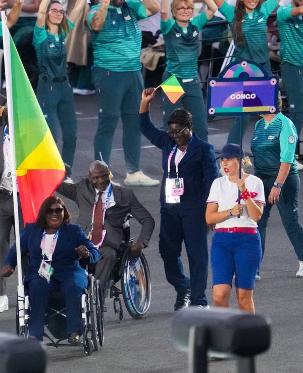 Emmanuel Grace Mouambako and Mireille Nganga tragen bei der Öffnungsfeier der Paralympischen Spiele am 28. August 2024 in Paris die Flagge Kongos.