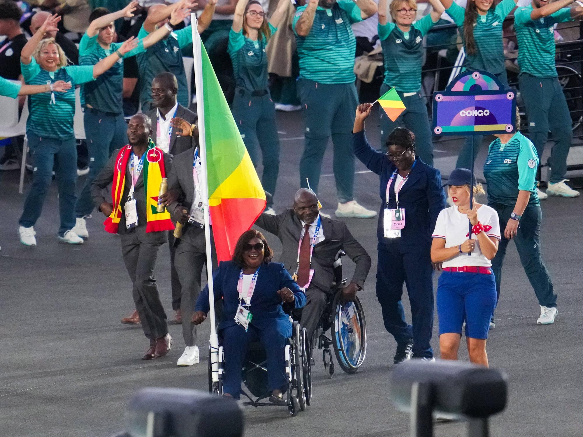 Emmanuel Grace Mouambako and Mireille Nganga tragen bei der Öffnungsfeier der Paralympischen Spiele am 28. August 2024 in Paris die Flagge Kongos.