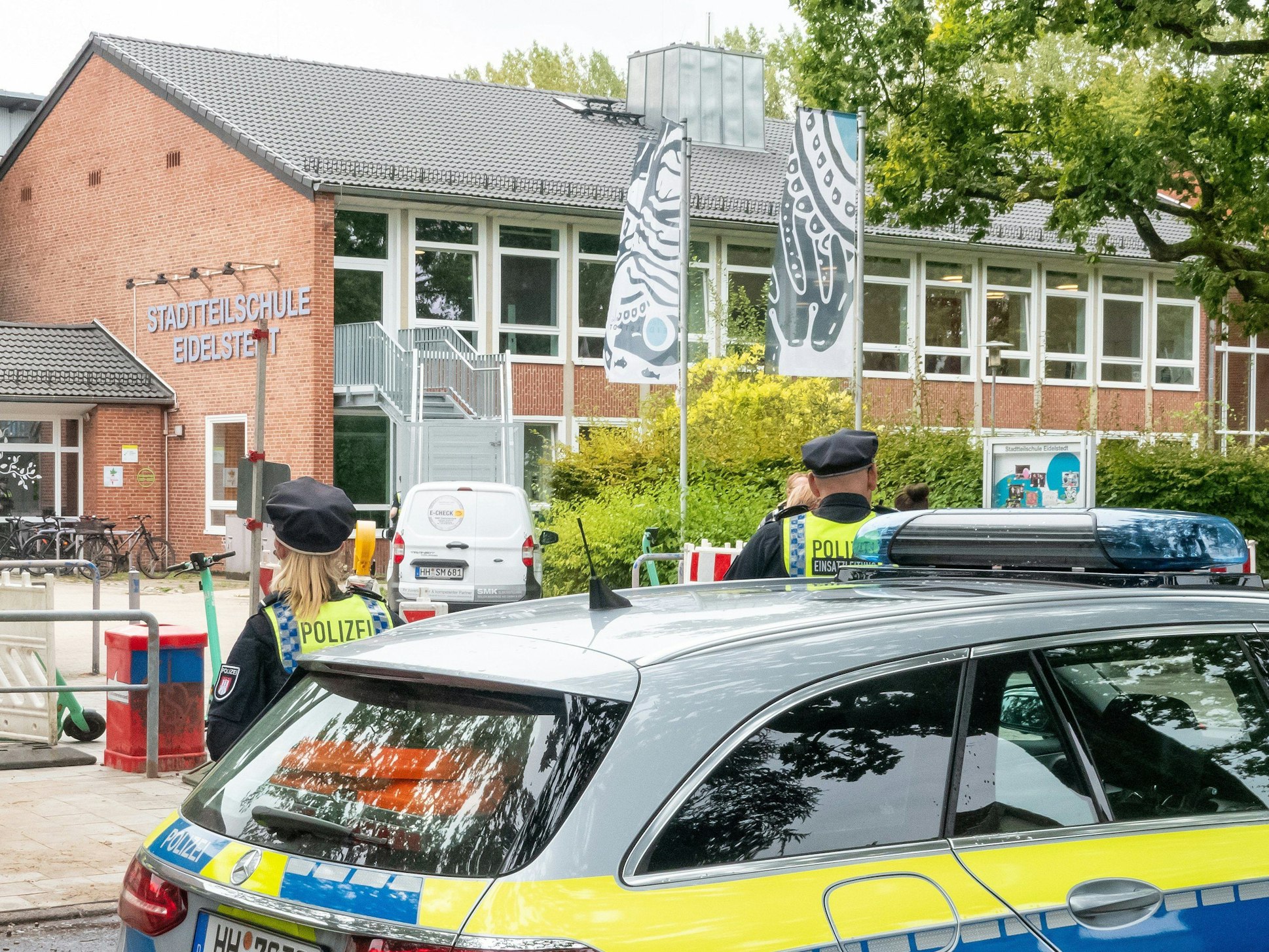 Ein Streifenwagen der Polizei steht vor einer Schule in Hamburg.