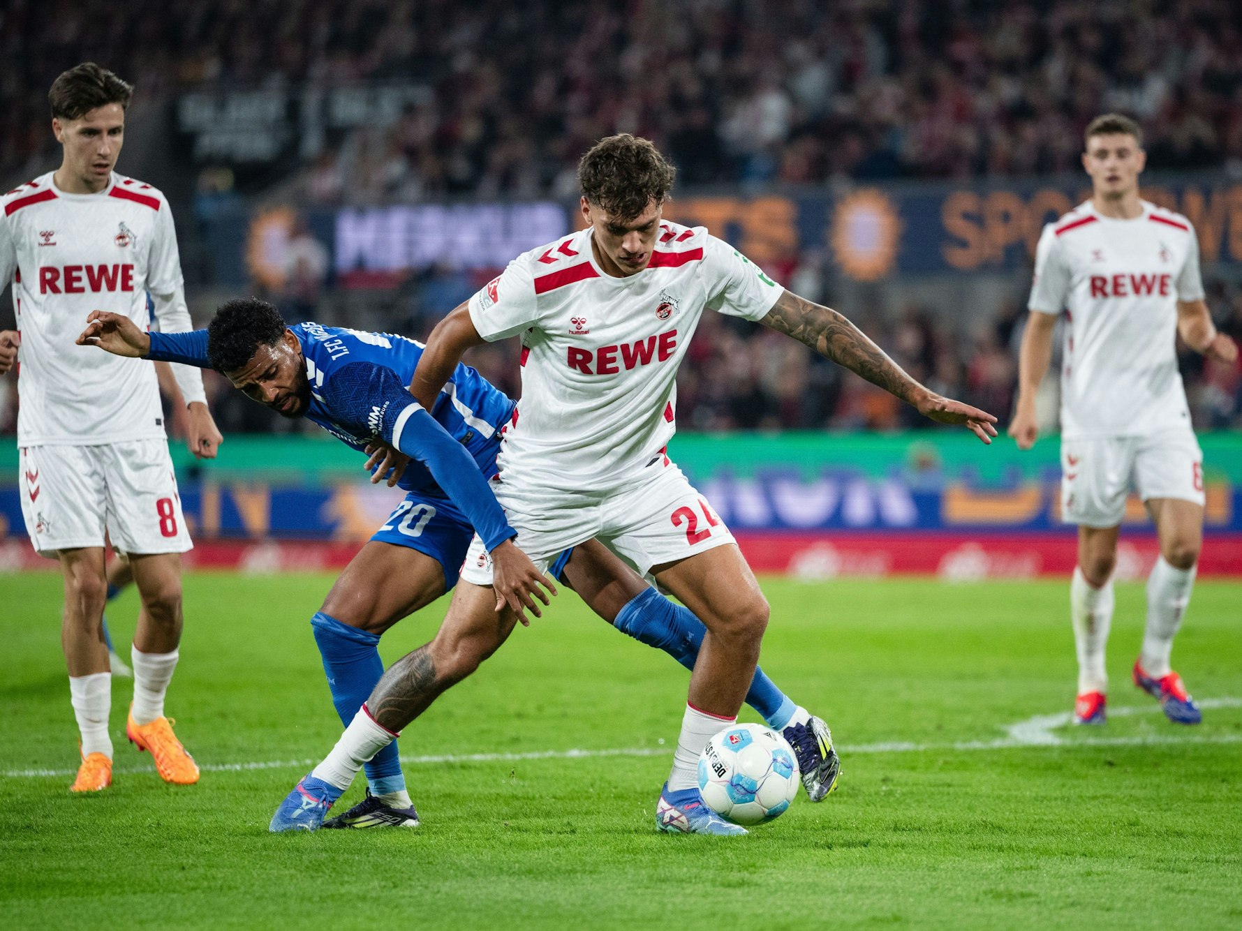 Kölns Julian Pauli (Mitte) und Magdeburgs Xavier Amaechi kämpfen um den Ball.