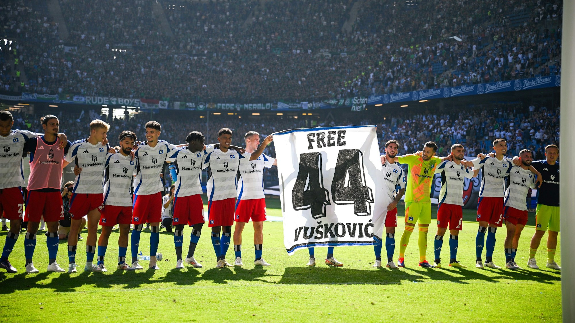 HSV-Spieler halten beim Jubel ein Banner für Mario Vuskovic hoch.