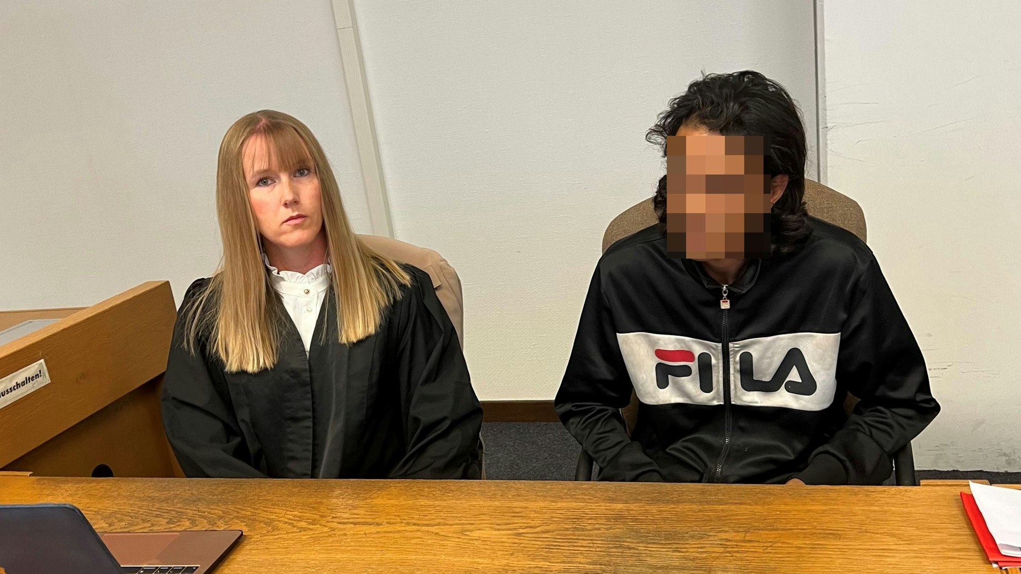 Der Angeklagte sitzt neben seiner Verteidigerin.