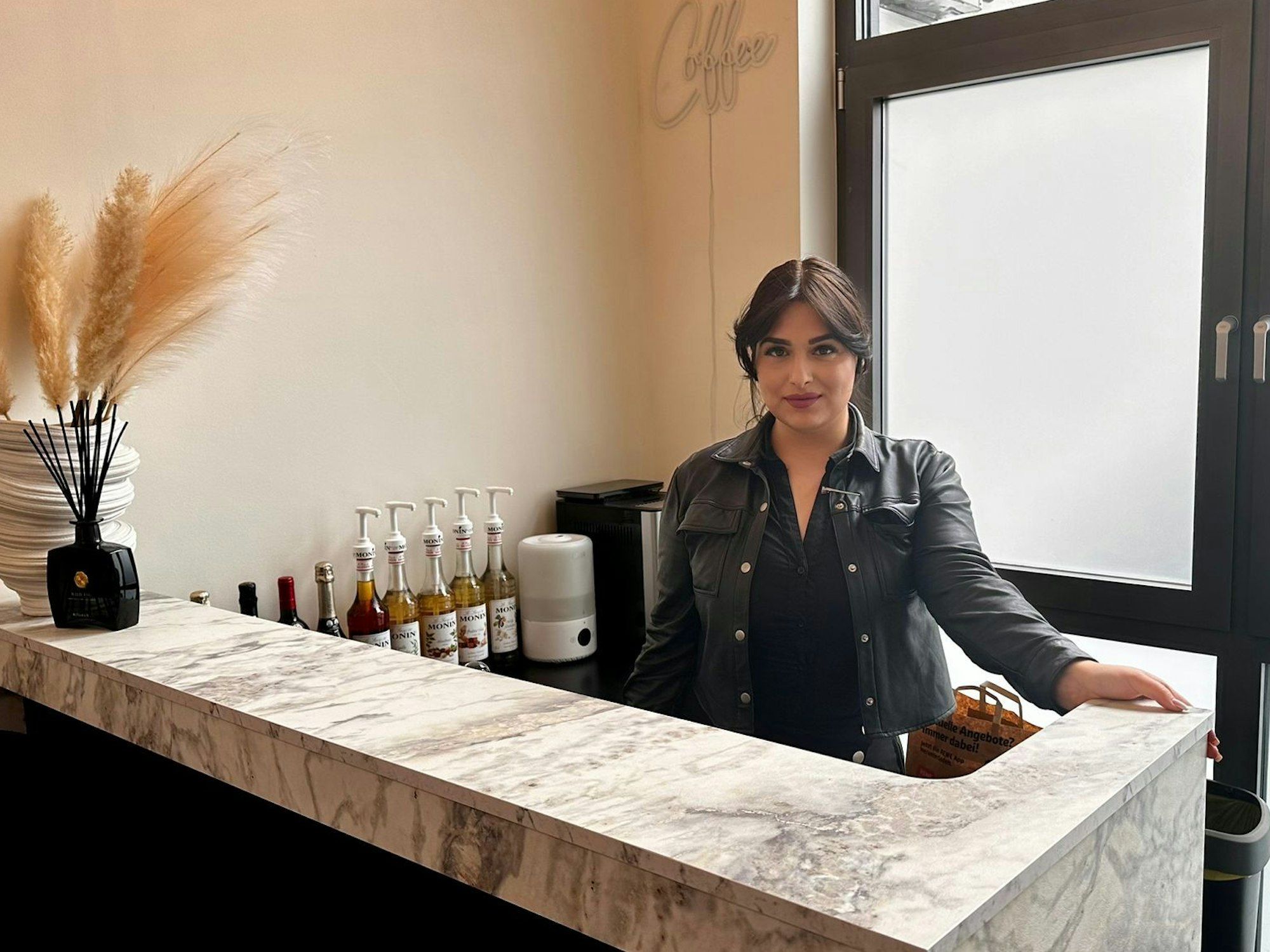 Sinem Kesmez steht hinter der Bar in ihrem Friseursalon.