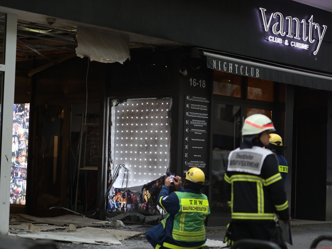 Feuerwehrleute stehen vor einem Gebäude nach einer Explosion.