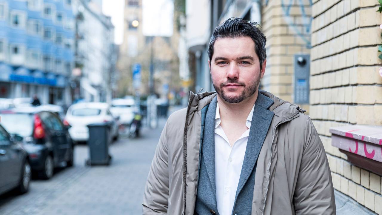 Stephan Hinz steht in lockeren Klamotten auf der Straße in Köln und schaut in die Kamera.