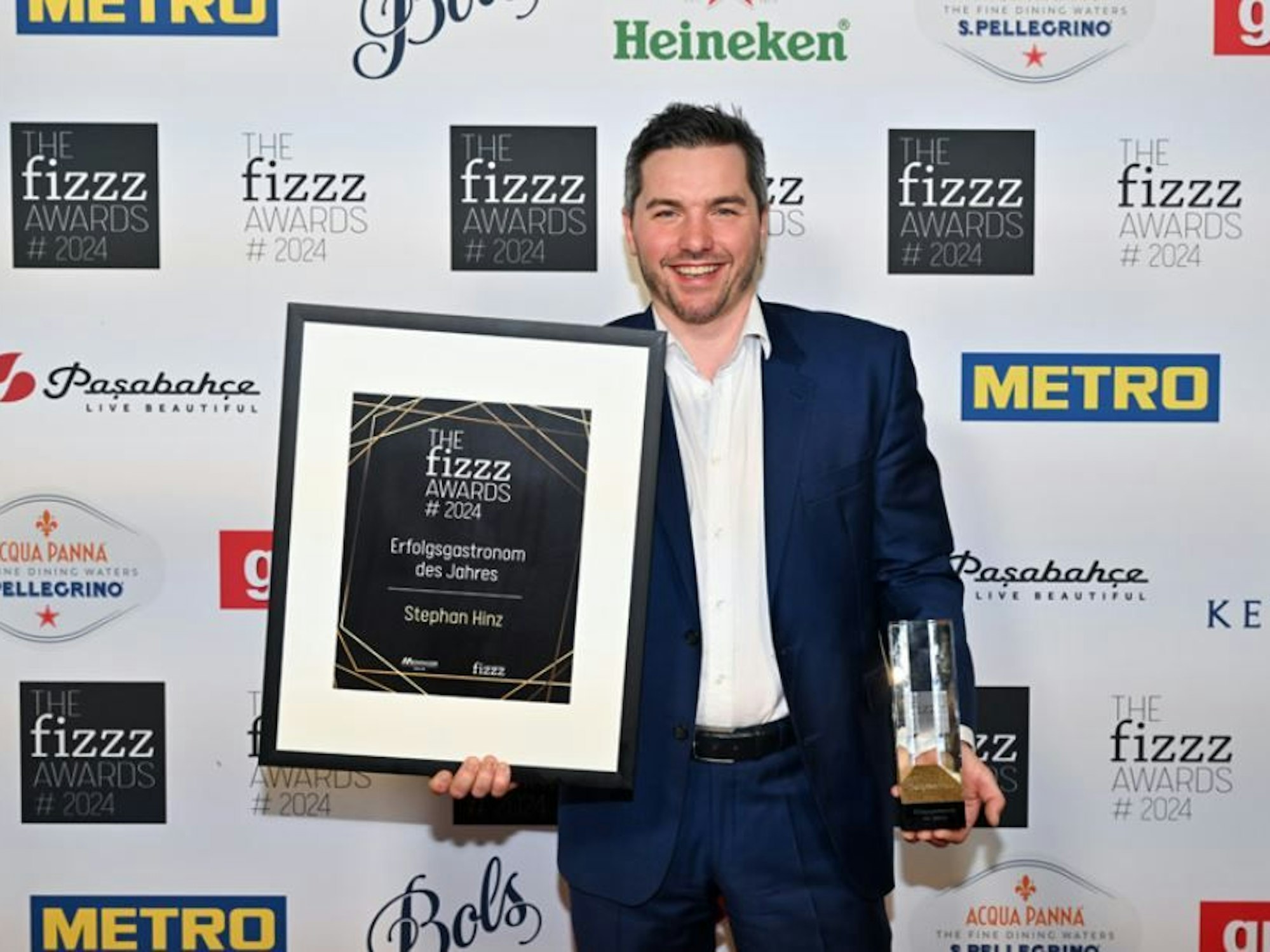 Stephan Hinz zeigt seine Auszeichnung im Rahmen der fizzz-Awards.