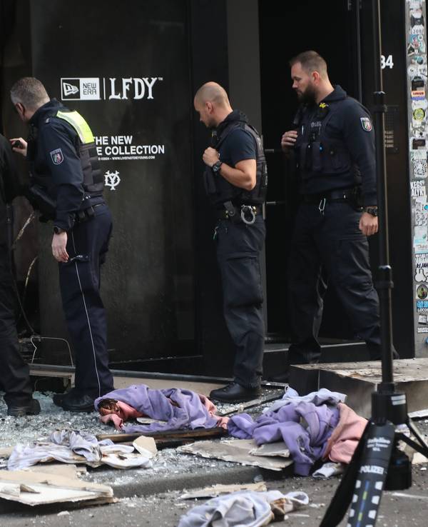Polizisten stehen vor einem Geschäft nach einer Explosion.