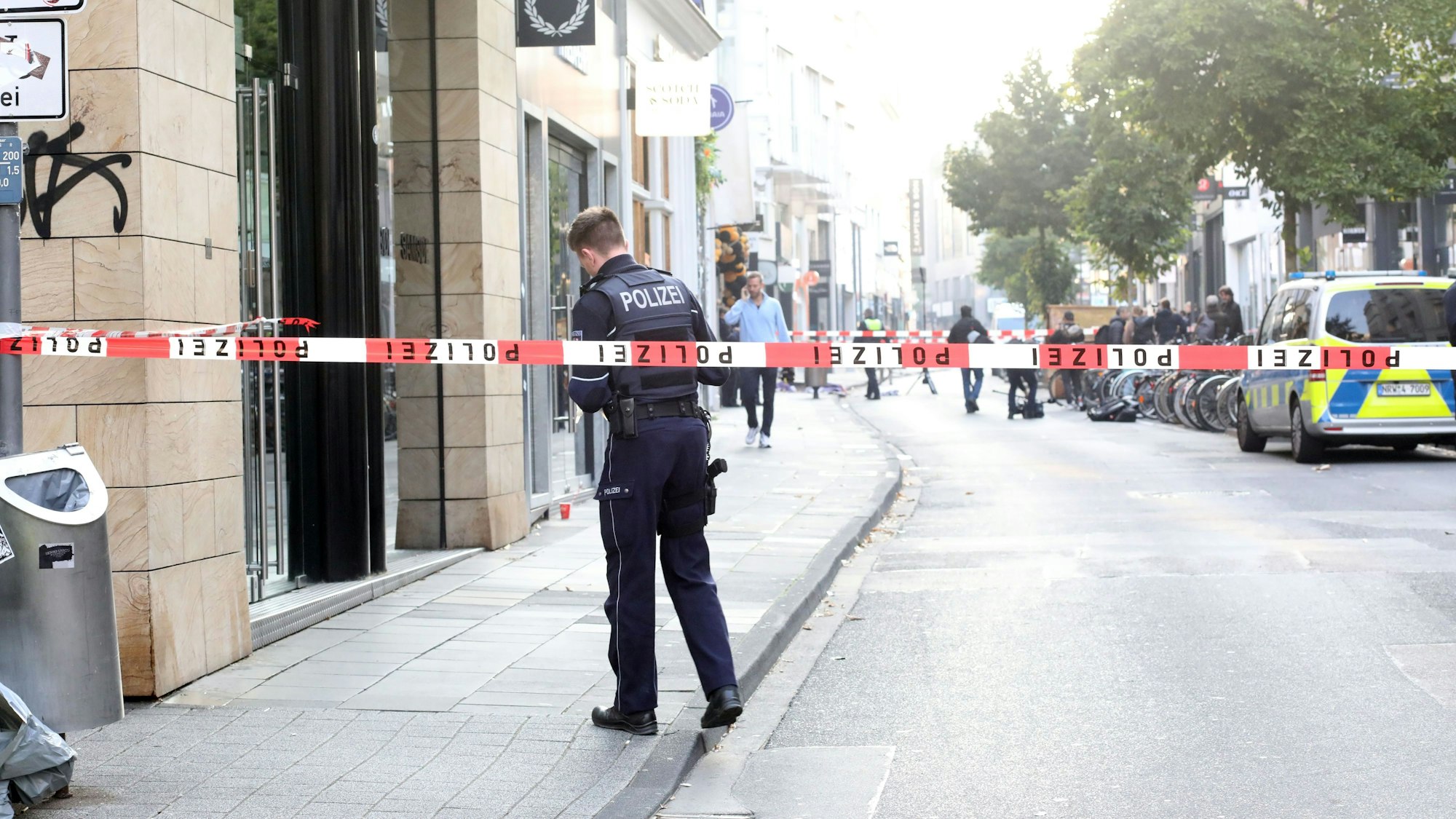Ein Polizist steht auf der Kölner Ehrenstraße und untersucht die Stelle, wo am Mittwoch (18. September) eine Explosion ausgelöst wurde.