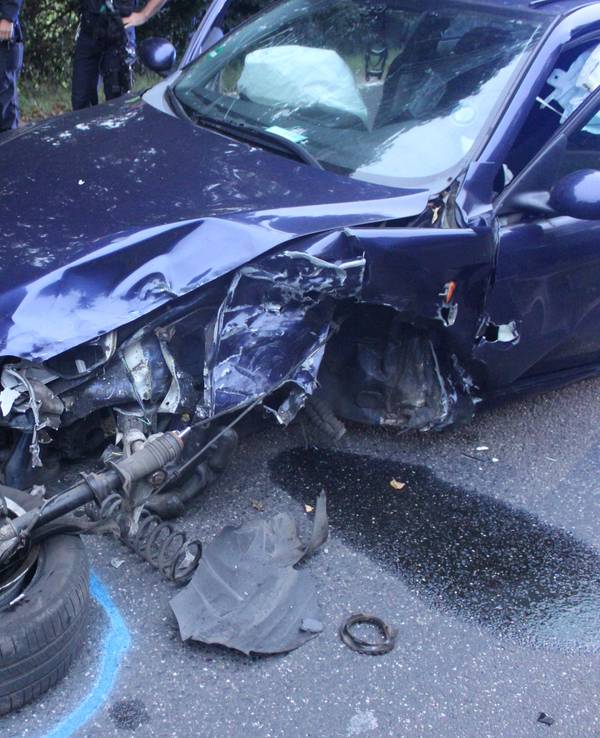 Ein zerstörtes Auto steht auf einer Straße nach einem Unfall.