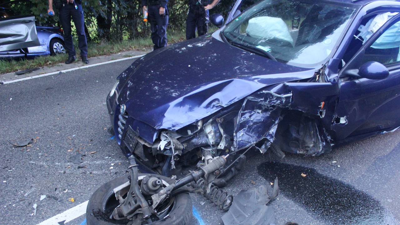 Ein zerstörtes Auto steht auf einer Straße nach einem Unfall.