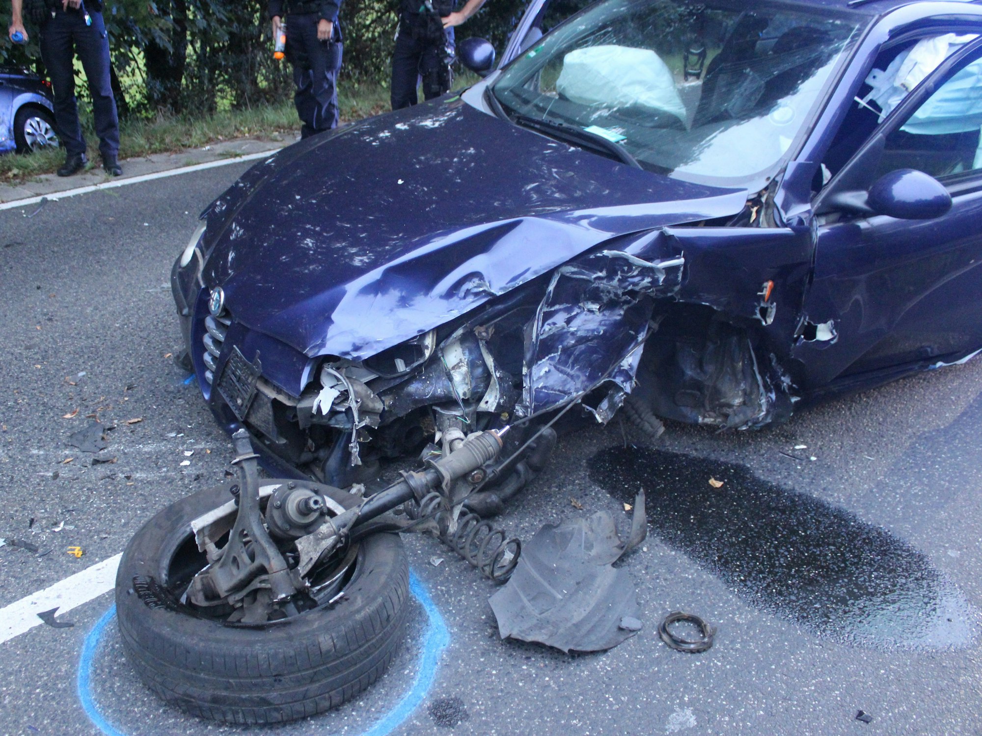 Ein zerstörtes Auto steht auf einer Straße nach einem Unfall.