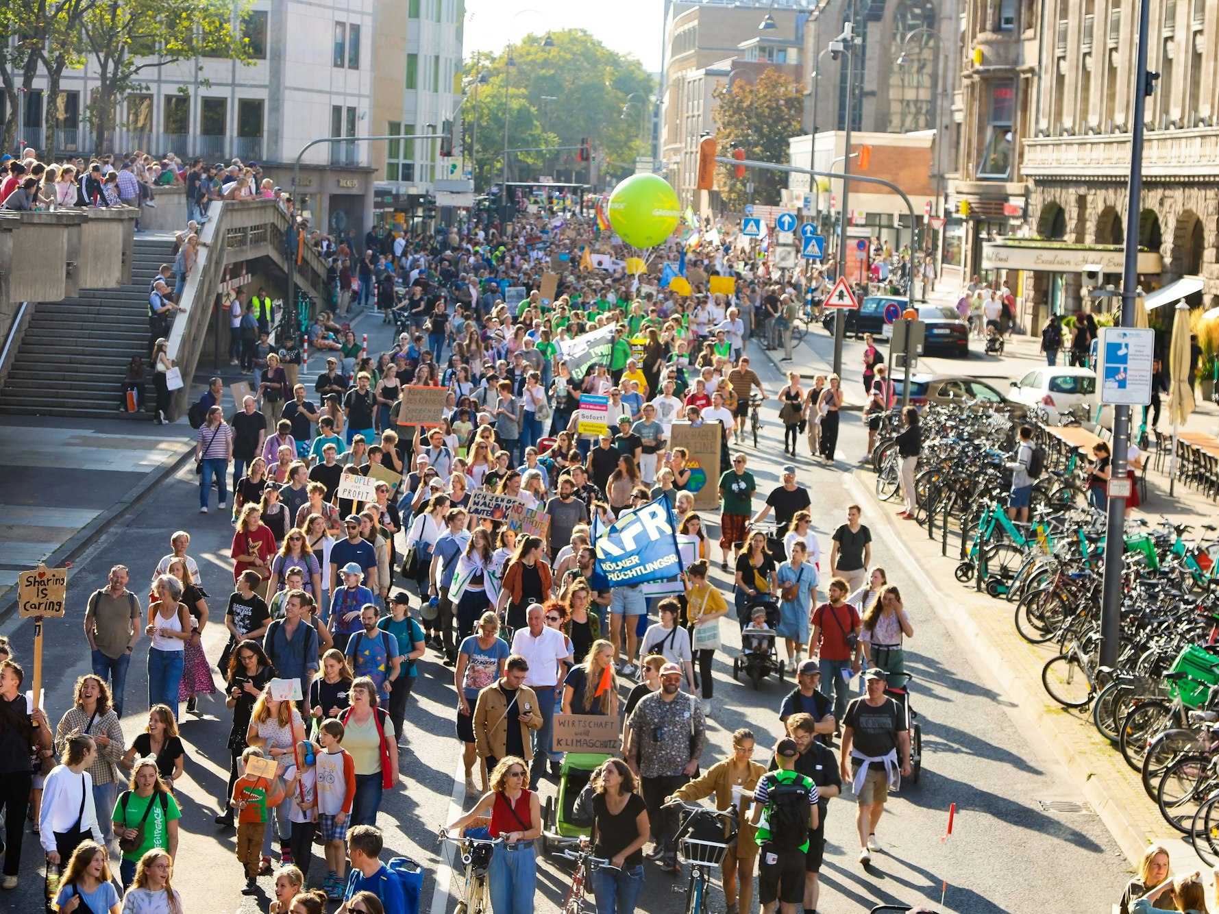 Menschen laufen bei einer Demo über eine Straße in Köln.