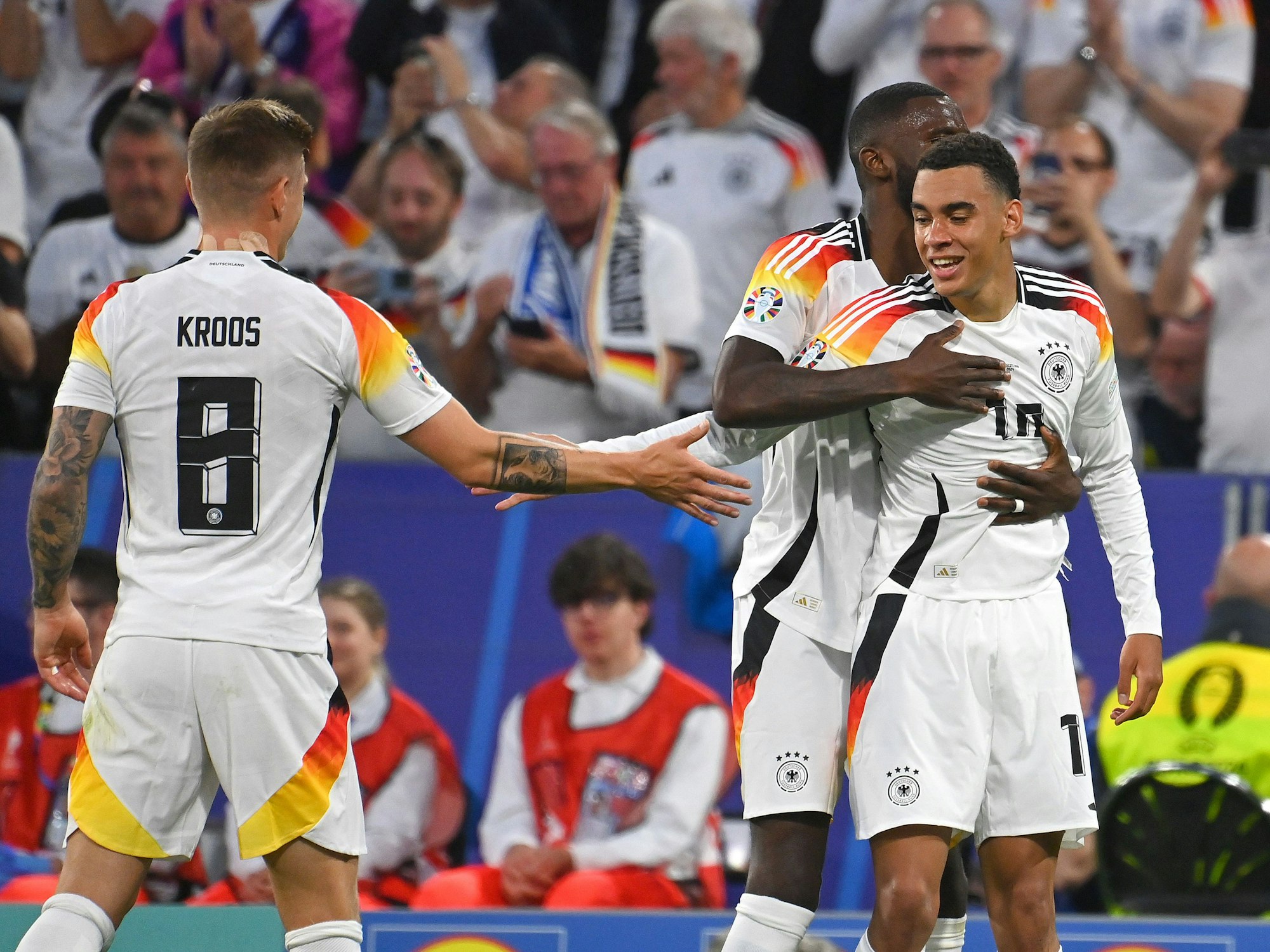 Toni Kroos, Jamal Musiala und Antonio Rüdiger bejubeln einen Treffer gegen Schottland.