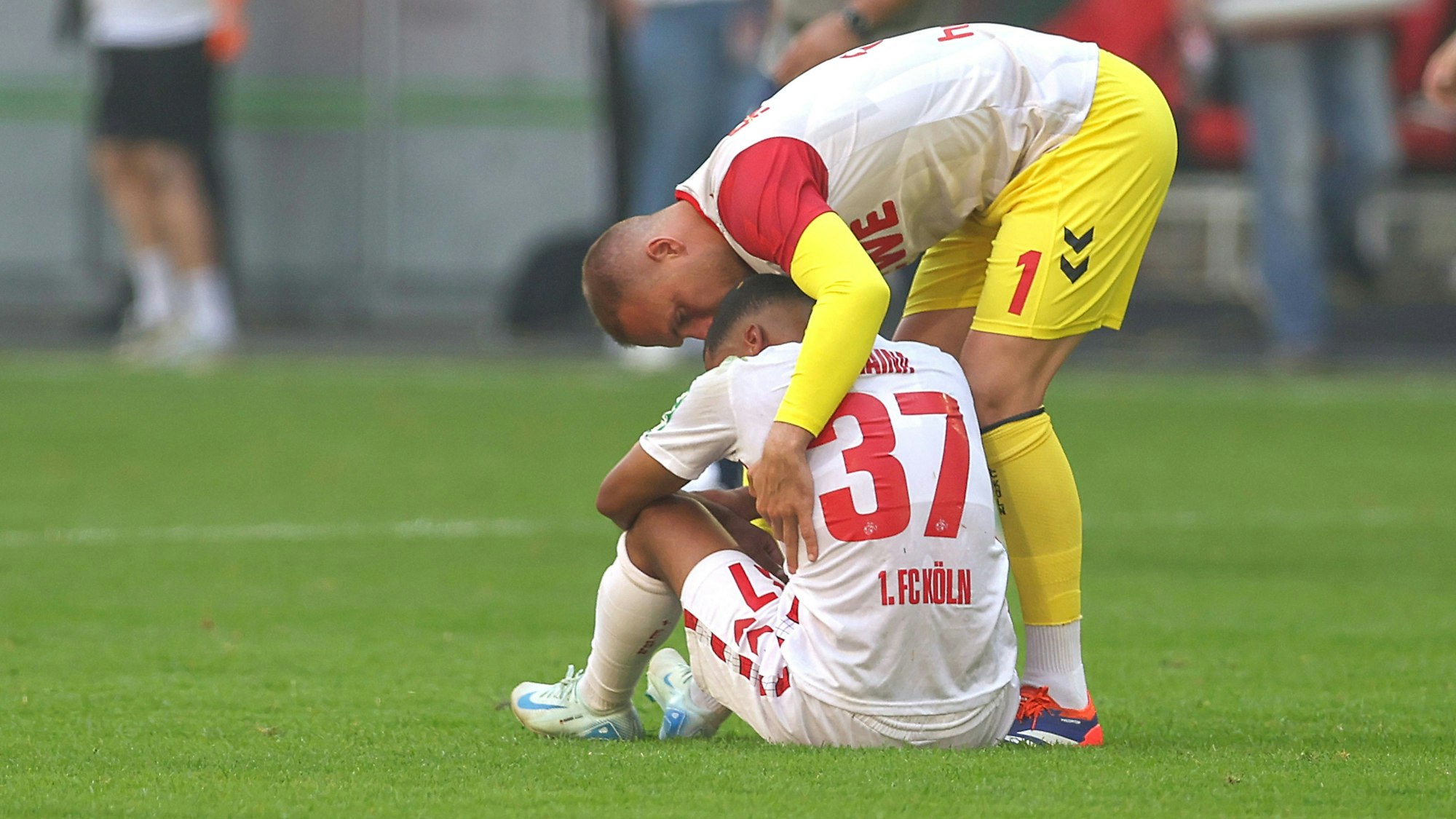 Linton Maina wird nach dem späten Ausgleich für Fortuna Düsseldorf gegen den 1. FC Köln am Samstag (21. September 2024) von Marvin Schwäbe getröstet.