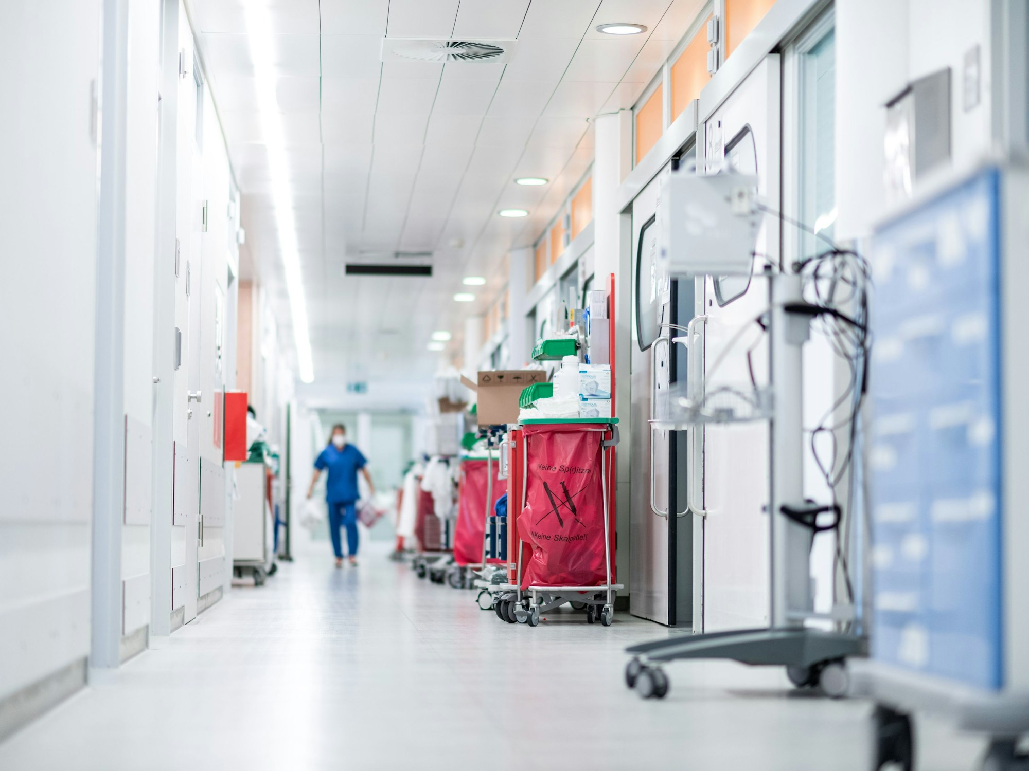 Eine Mitarbeiterin der Pflege läuft über einen Gang auf der Corona-Intensivstation des Universitätsklinikums Essen.