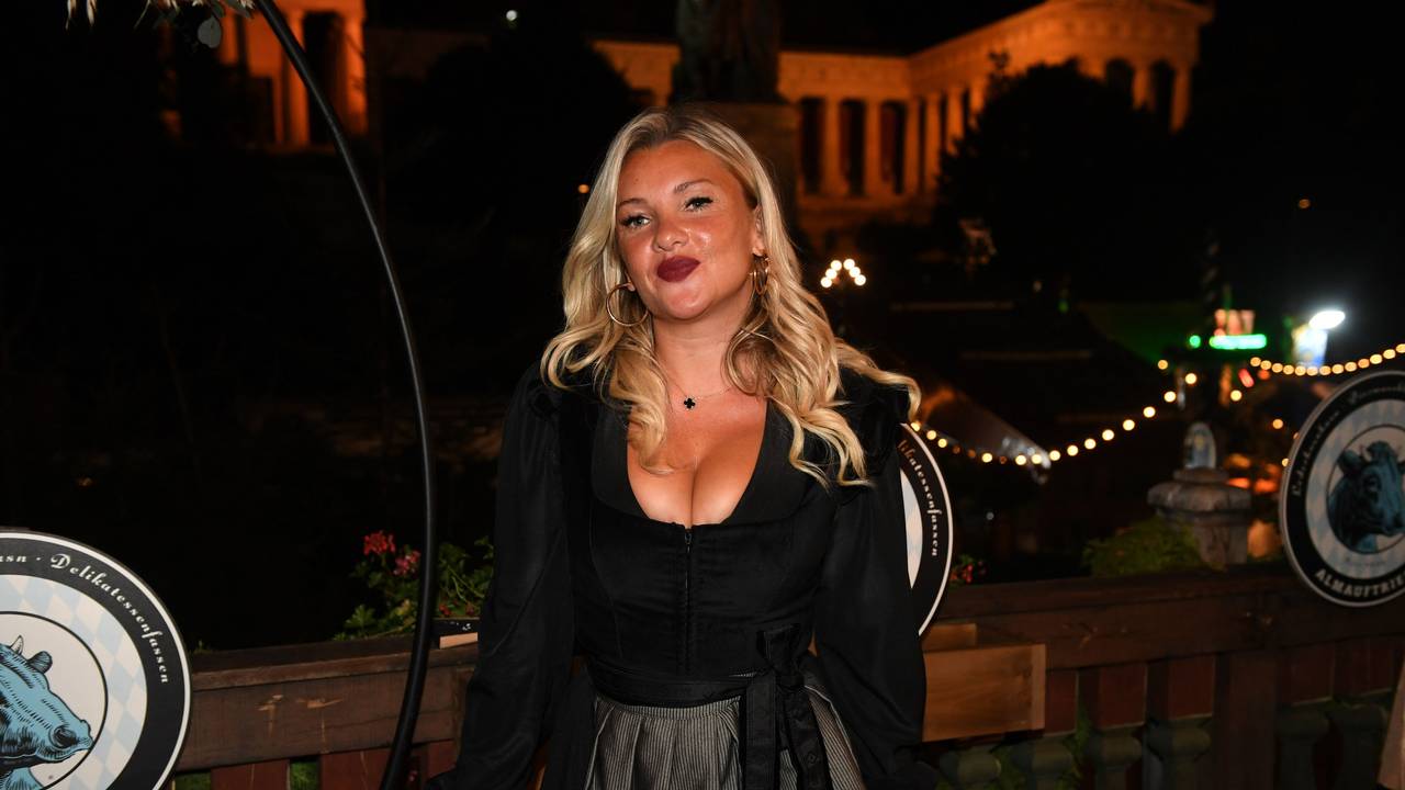 Der TV-Star Evelyn Burdecki steht dem Balkon des Käferzelt beim Almauftrieb auf der Wiesn.