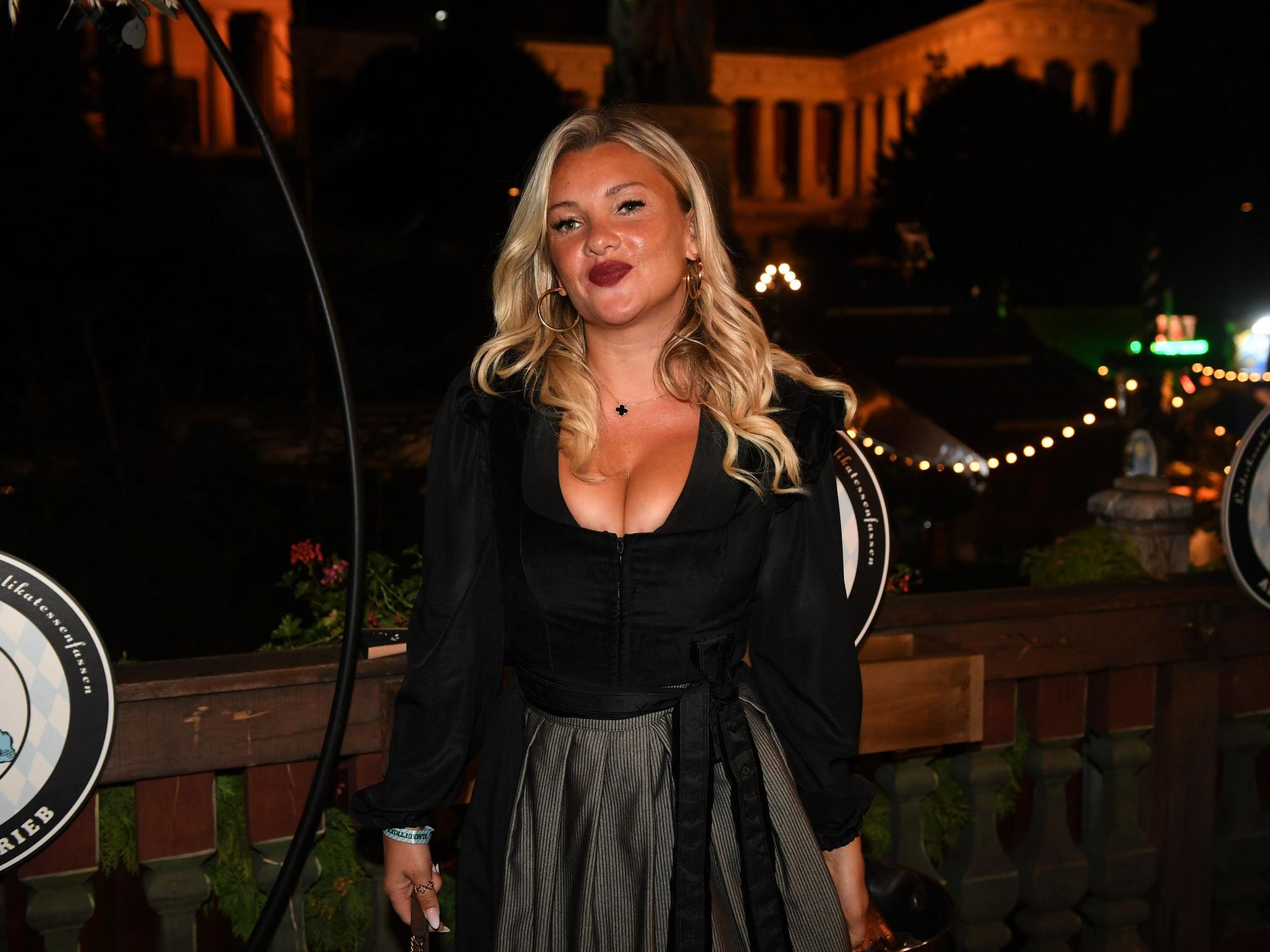 Der TV-Star Evelyn Burdecki steht dem Balkon des Käferzelt beim Almauftrieb auf der Wiesn.