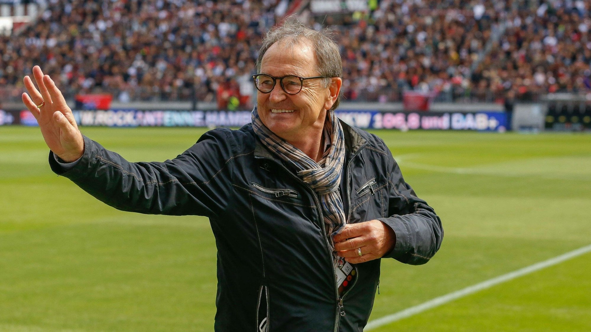Ewald Lienen winkt im Stadion.
