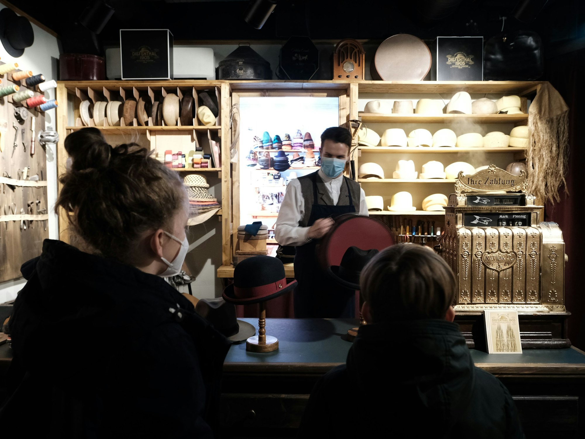 Zwei Gäste von TimeRide stehen vor dem Hutmacher.