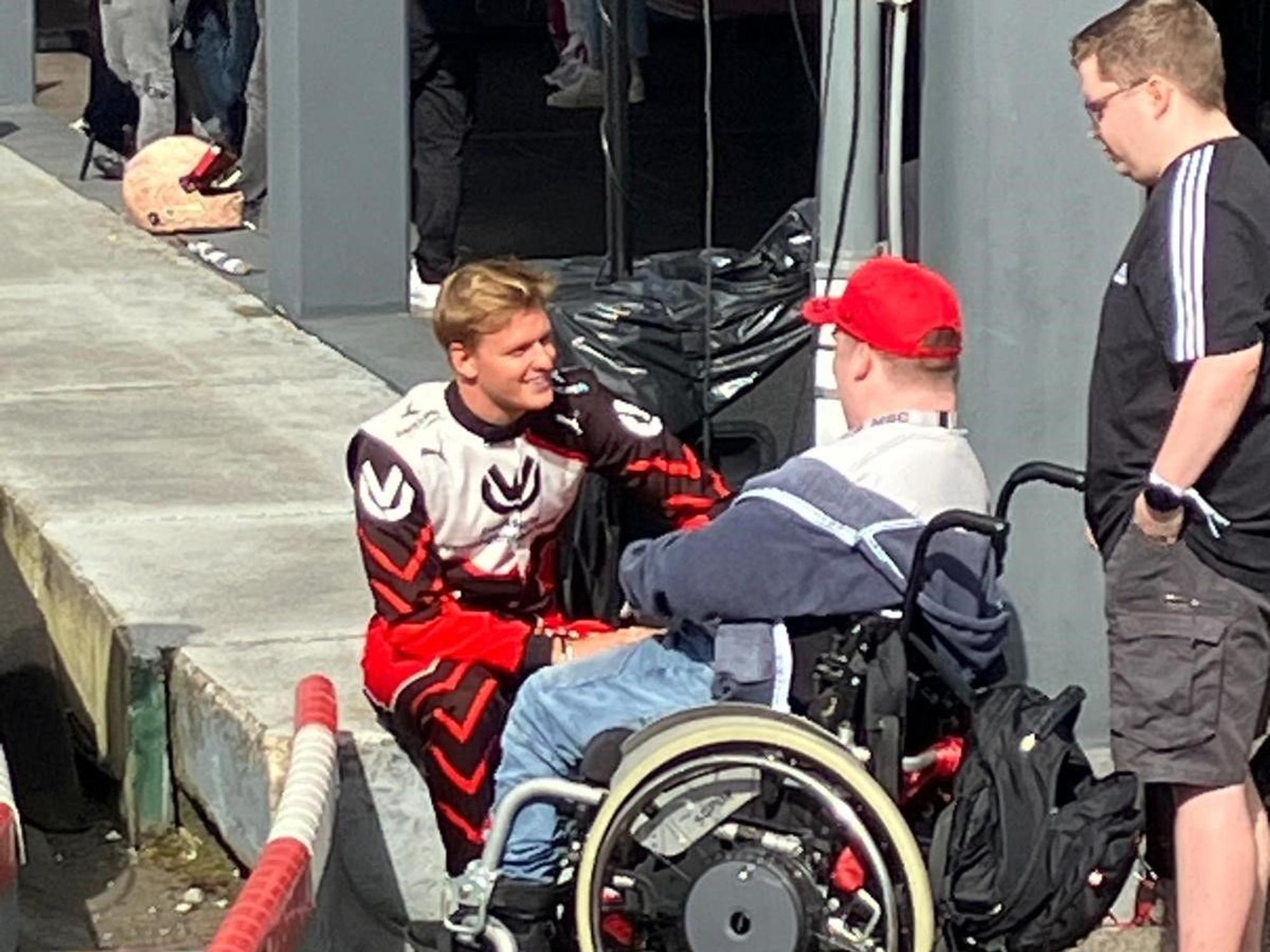 Mick Schumacher spricht mit Rollstuhlfahrer Tim (19) aus Birken Honigessen, der an einem Hirntumor erkrankt ist.
Foto: Heiko Debus
